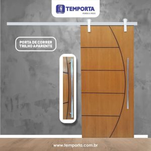 Porta de correr de madeira com trilho aparente e puxador tubular em inox, design moderno com frisos decorativos, ideal para ambientes internos sofisticados e otimização de espaço.