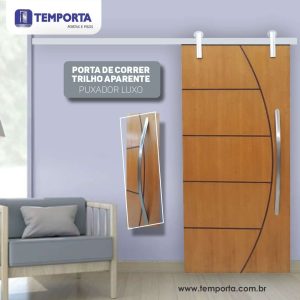 Porta de correr de madeira com trilho aparente e puxador luxo curvo, modelo moderno para interiores – Temporta Portas e Pisos.